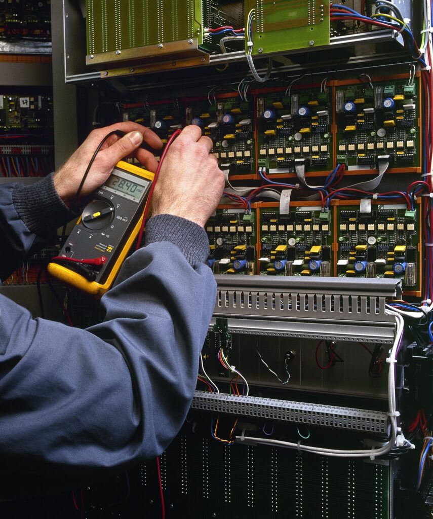PLC Programming Services - electrician working on board